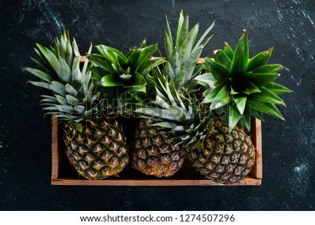 Pineapple in a wooden box. Tropical Fruits. Top view. Free copy space.
