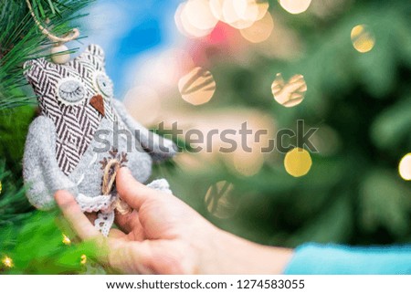 Christmas toy in the hands of a child.Children hands hold the decor at the Christmas tree on which the New Year's toys are hanging . Xmas concept.