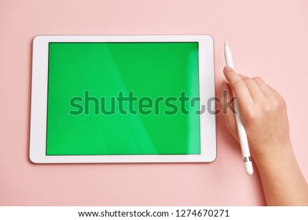 hand draws a pencil on a tablet with a chromakey on the screen
