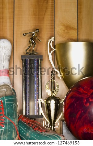 Bowling ball and pin with shoes and trophies