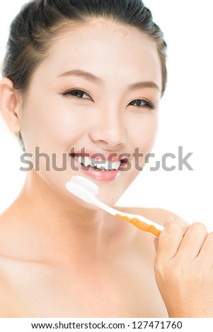 Vertical portrait of a cheerful young woman holding a toothbrush with toothpaste