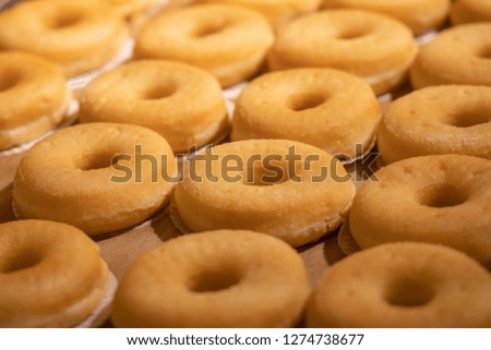 a lot of donut on tray in supermarket
