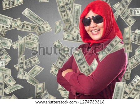 Portrait of happy successful young Asian billionaire woman smiling happily under rain of money. Wealth investment economic concept