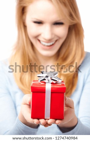 A beautiful young blond woman smiling, holding a red gift box with a silver bow, isolated on white.