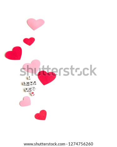 Phrase I Love You constructed from white letter cubes, Pink and Red Hearts on a White Background. Romance Valentine Mother's Day concept. 
