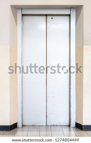 Close up closing elevator silver door inside old building.