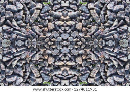 A symmetrical pattern formed by pattern of crushed granite gray, white and red shades. The image with the mirror effect. Amazing seamless pattern of stone texture.