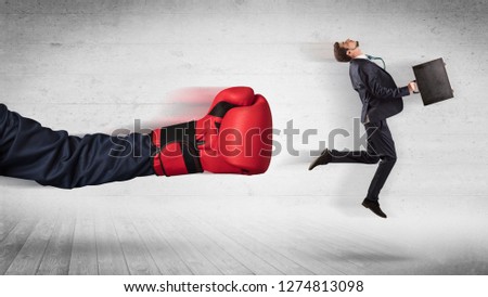 Arm with red boxing gloves hits office worker concept