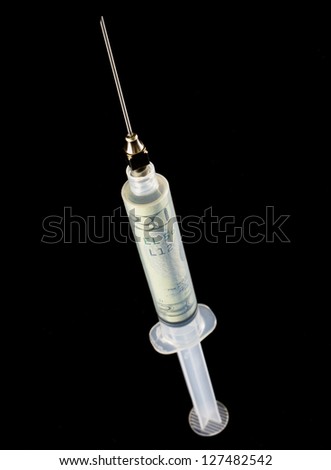 Syringe with twenty dollar bill inside over black background