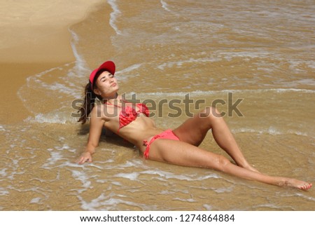 Asian girl in red bikini relax on sunny beach.  