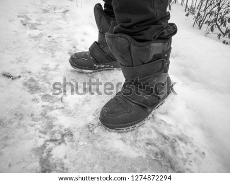 Boots on the feet of a man in winter .