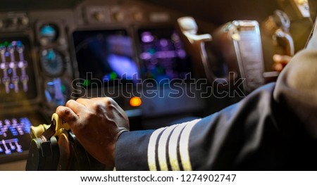 Cropped Hands of African Pilot flying a commercial airplane, cockpit view close up of hands Royalty-Free Stock Photo #1274902747