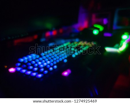 Blurred Table full of Colorful RGB Gaming gears like Mouse, keyboard, mousepad, and headset. High end equipment used by gamer to play video game on PC