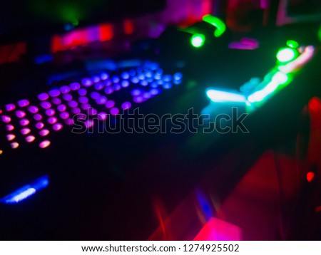 Blurred Table full of Colorful RGB Gaming gears like Mouse, keyboard, mousepad, and headset. High end equipment used by gamer to play video game on PC