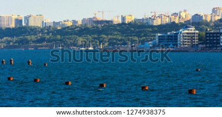 Magnificent panorama, view from the sea to the coastal strip of the city before sunset in the soft sunlight. High-rise buildings and commercial facilities on the shore