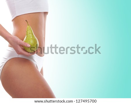 Dieting concept, Beautiful belly and a fruit isolated on blue