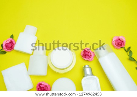 Cosmetics products on yellow background with copy space