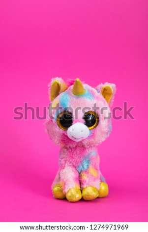 Toy Pink Unicorn sits on a pink background.