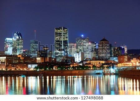 Montreal over river at dusk with city lights and urban buildings