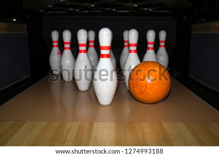 bowling pins and bowling orange on a wooden bowling alley. Pinsetter