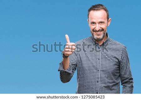 Middle age hoary senior man over isolated background doing happy thumbs up gesture with hand. Approving expression looking at the camera with showing success.