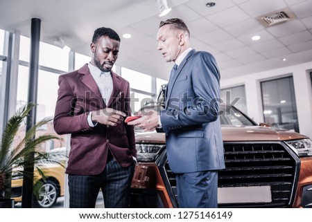 Prosperous client. African-American sales manager wearing stylish jacket consulting his prosperous client