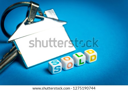 Keys with a keychain form the house and the inscription on the sale.