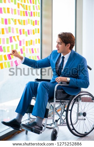 Young handsome man in wheelchair with many conflicting prioritie