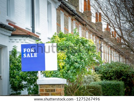 A street of of house with 'For Sale' sign- UK