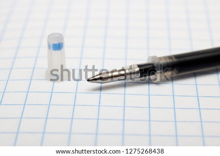 The core for a pen on the background of a sheet of notebook Royalty-Free Stock Photo #1275268438