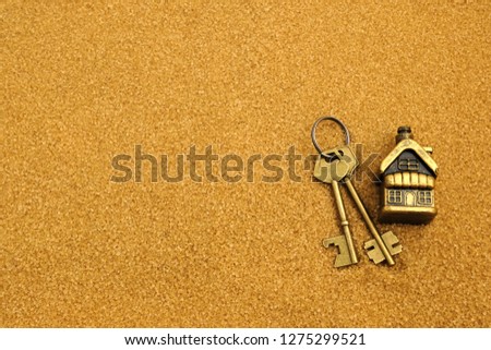 House and key on the yellow sand. Concept - purchase, sale, rental of real estate. Installment loans, mortgages. A gift on vacation, on vacation.
