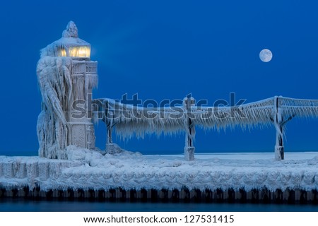 Ice accumulates on the St. Joseph North Pier Lighthouse at dusk in the Winter in Saint Joseph, Michigan on February 6, 2013 Royalty-Free Stock Photo #127531415