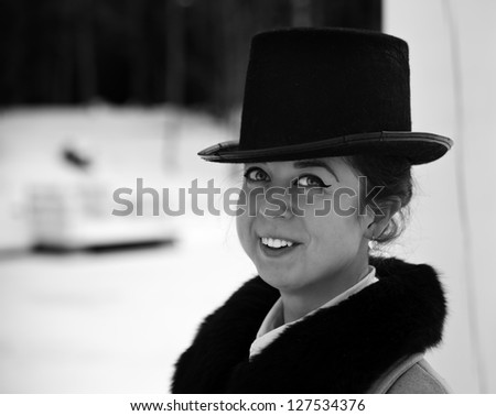 Shaded portrait of smiling young woman with hat