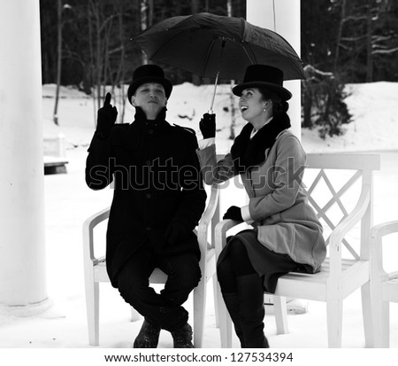 Shaded man and woman waiting rain under umbrella