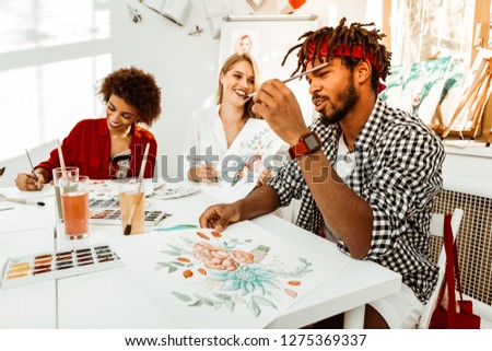 Man with pencil. Bearded man wearing red smart watch holding pencil while attending painting classes