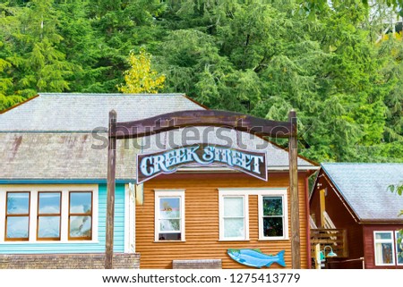 Entrance to Creek Street, popular shopping tourist attraction landmark in Ketchikan, Alaska. Colorful architecture wooden buildings/ shops on stilts on a river usually filled with salmon/ other fish.