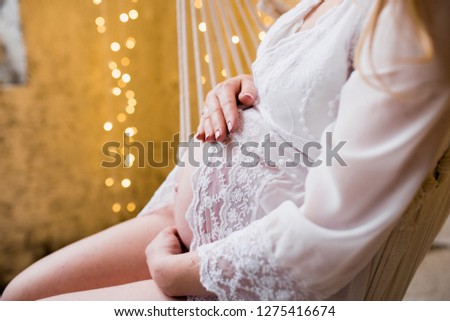 Pregnant woman covering her belly with lace