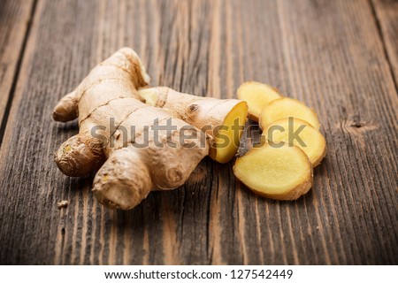 Ginger root sliced on wooden table Royalty-Free Stock Photo #127542449