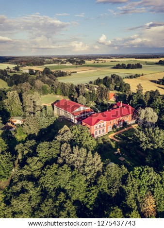 Aerial Photo of Old Castle turned into School in Countryside Between Trees with Dramatic Clouds over it in Early Spring on Sunny Day - Concept of Peaceful Life in Countryside in Harmony, Vintage