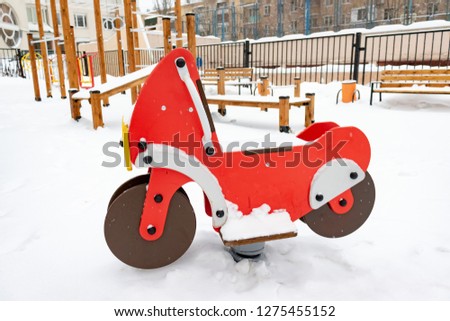 Children's deserted playground in winter after heavy snow.
