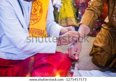 Indian pre wedding Haldi red thread on a wrist