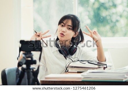 Happy Asian woman videoblog / blogger vlogger recording online course or tutorial coach presentation pass video for teaching live homework sharing online channel social media by mirrorless camera