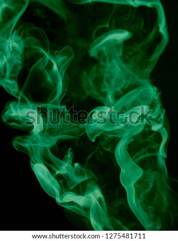 A thick waft of green smoke over a black background/vibrant semi-abstract smoky textured overlay pattern. 