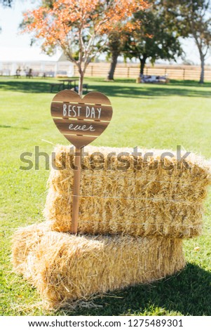 Two hay bails with heart shaped sign with words "Best Day Ever"