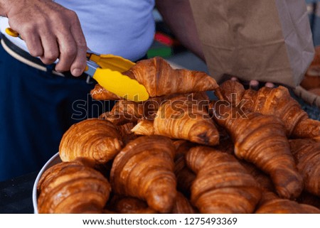 Selling croissants at the farmers market. Close up picture shot outside on a sunny day in a french farmer's market of Quebec, Canada.