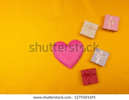 Valentines day background with red heart and gift box on glitter lights gold background.