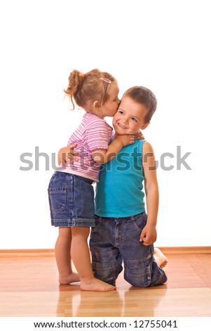 Little girl kissing her older brother on the cheek - isolated