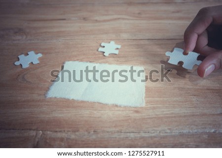 Closeup hand of woman connecting jigsaw puzzle with sunlight effect, Business solutions, success and strategy concept - Image