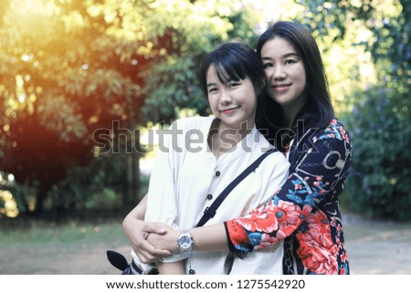 
A cute Asian mother and child is standing in a different position. In one place There is a background image of the bokeh.