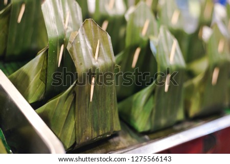 Thai dessert that cover snack inside with banana leaf and seal with a toothpick